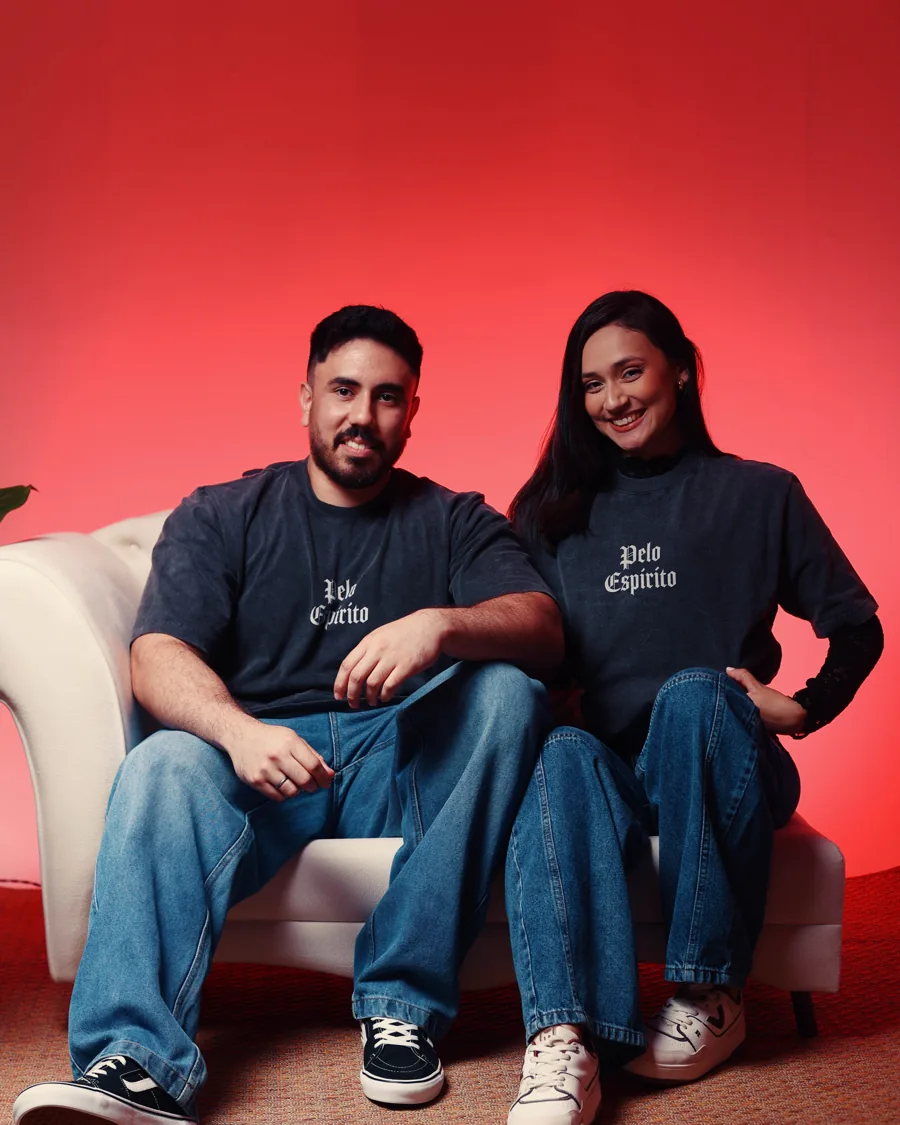 Casal vestindo a camiseta preta estonada com 'Pelo Espírito' escrito no peito